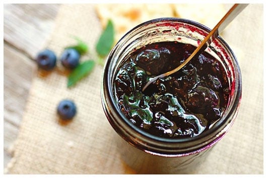 Top view of a jar of blueberry jam with a spoon