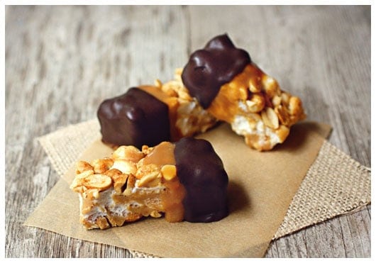 Three Chocolate Dipped Salted Nut Roll Bars on brown paper