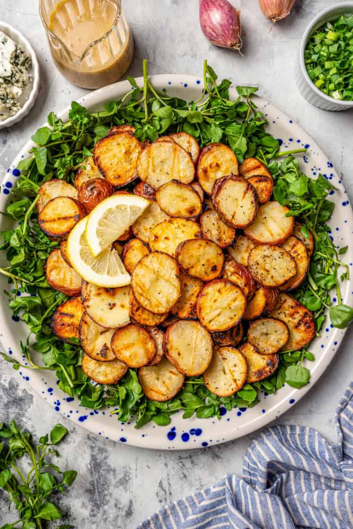 Overhead view of grilled potato salad on platter with watercress