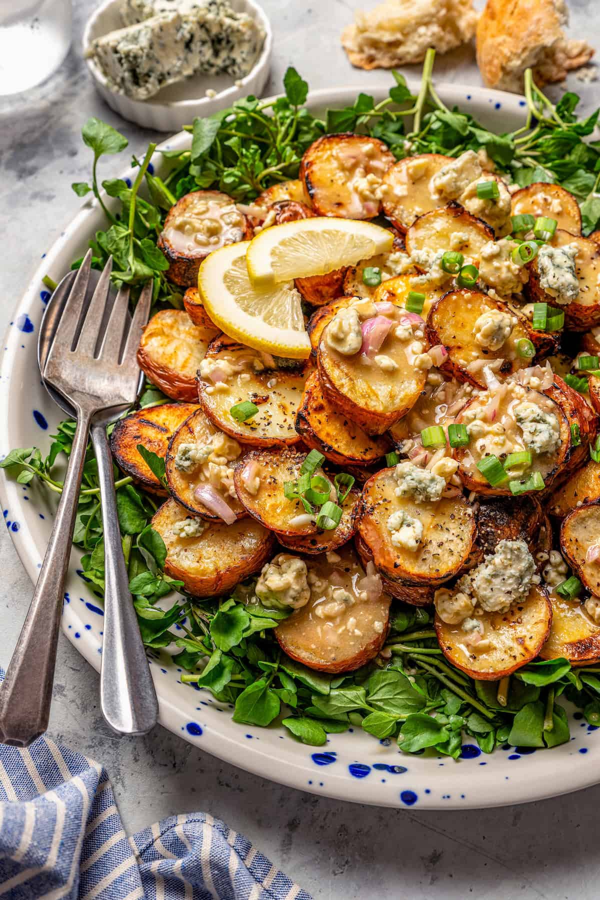 Grilled potato salad with blue cheese vinaigrette on platter with two forks