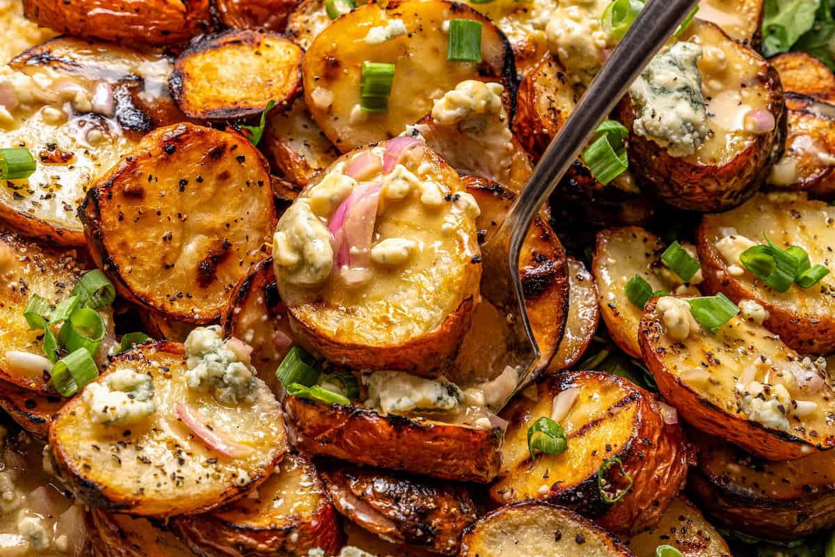 Closeup of grilled potato salad with fork digging in