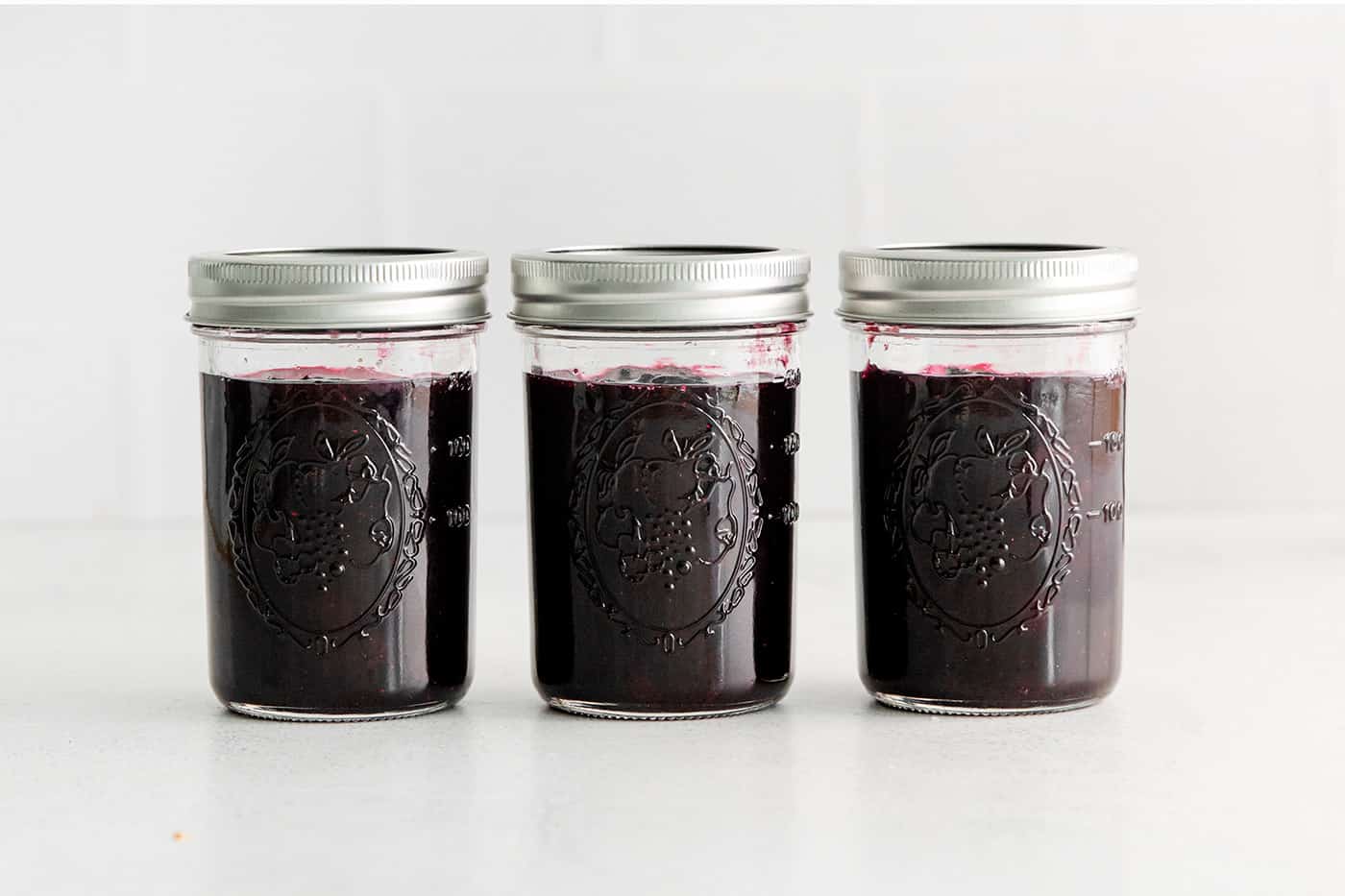 Three jars of blueberry jam with mint