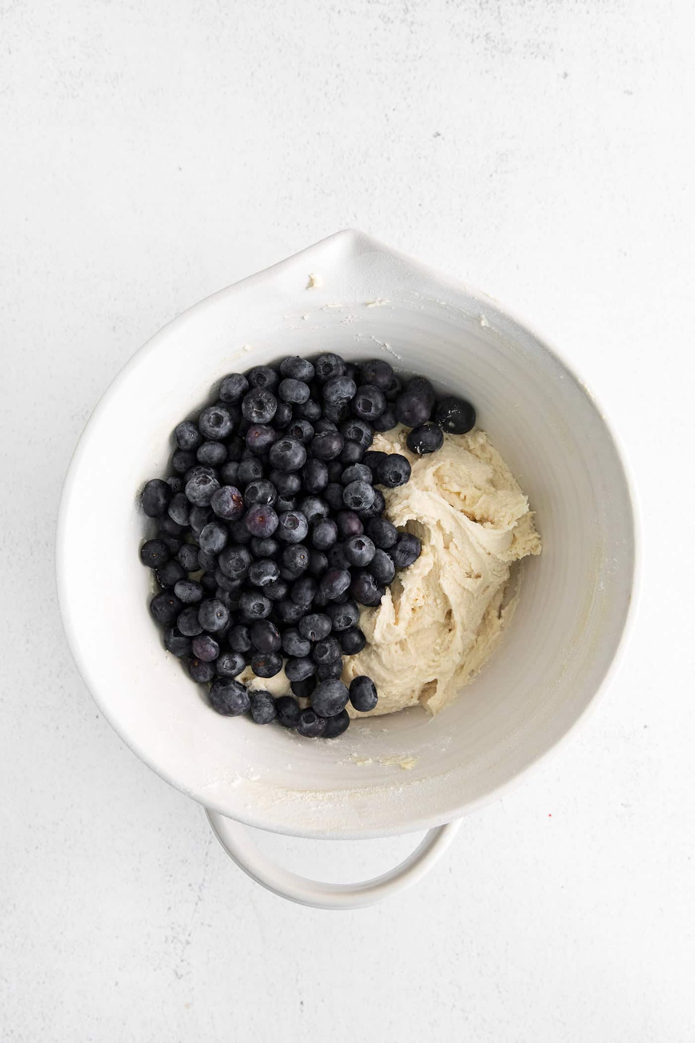 Blueberries added to cake batter in a mixing bowl