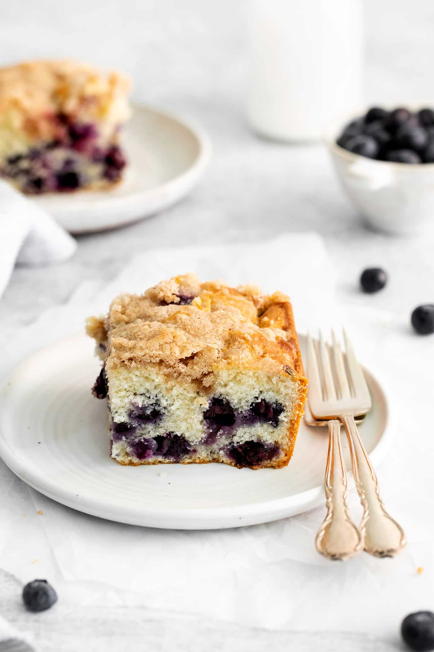 A slice of blueberry cake on a white plate
