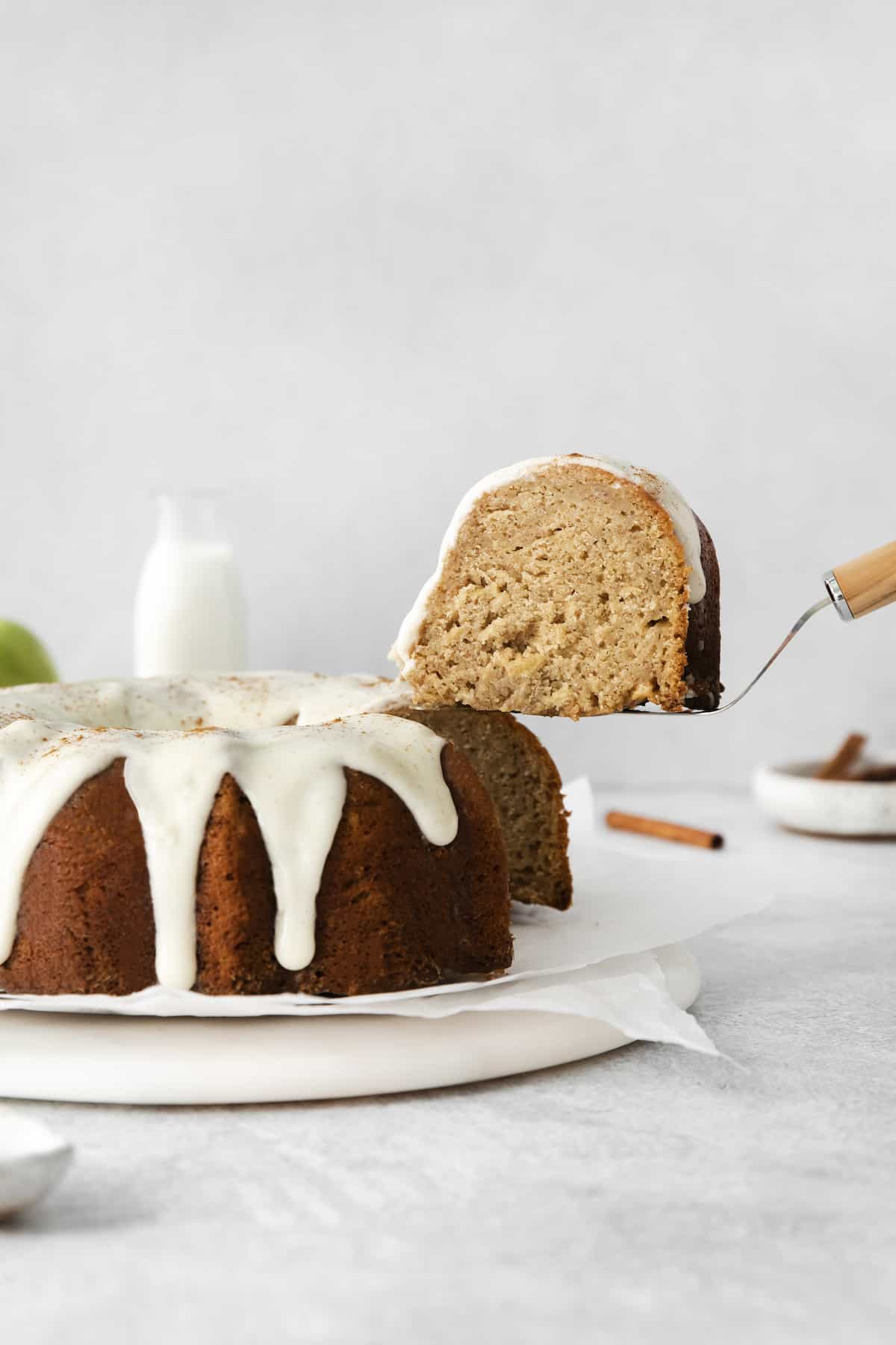 An apple bundt cake with a slice on a serving utensil