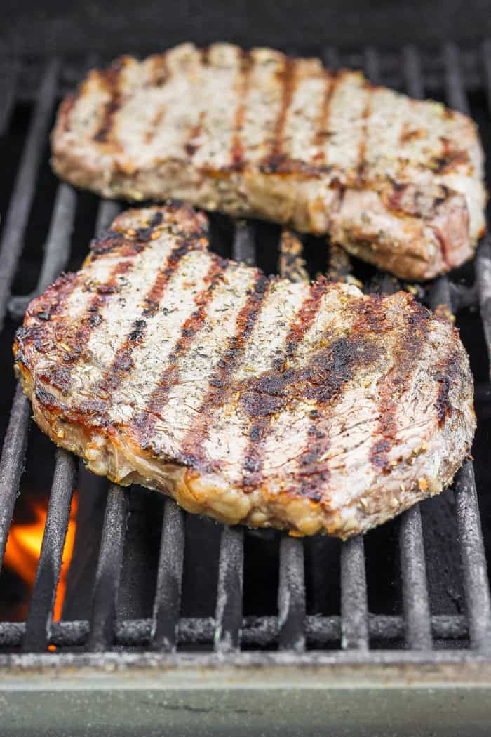 Two ribeye steaks on grill.