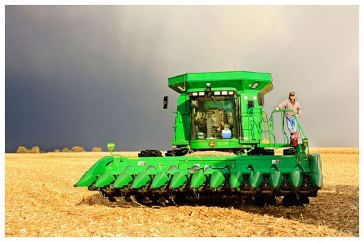 A Man Standing on a Bright Green Combine