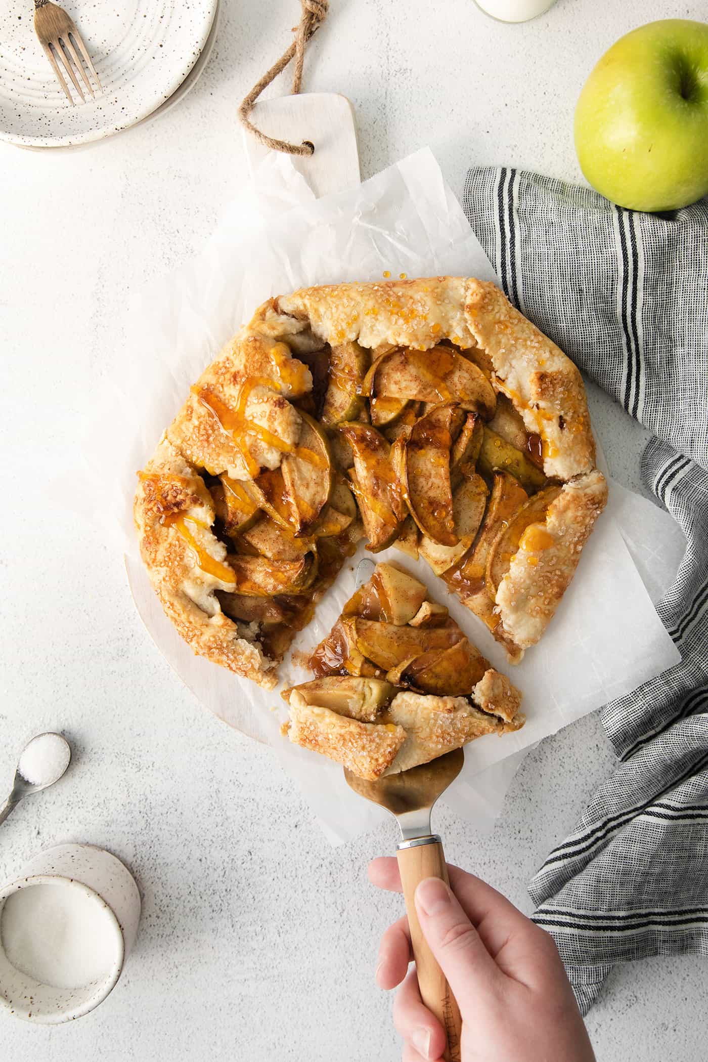 Overhead view of a slice of almond apple galette being served