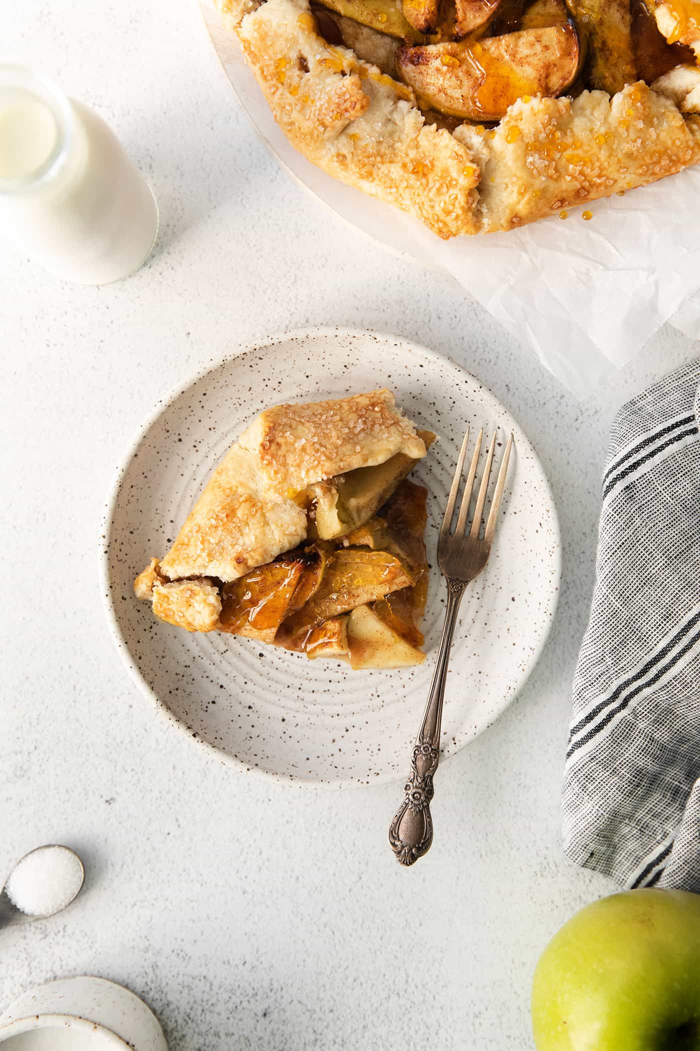 A slice of apple almond galette on a white plate