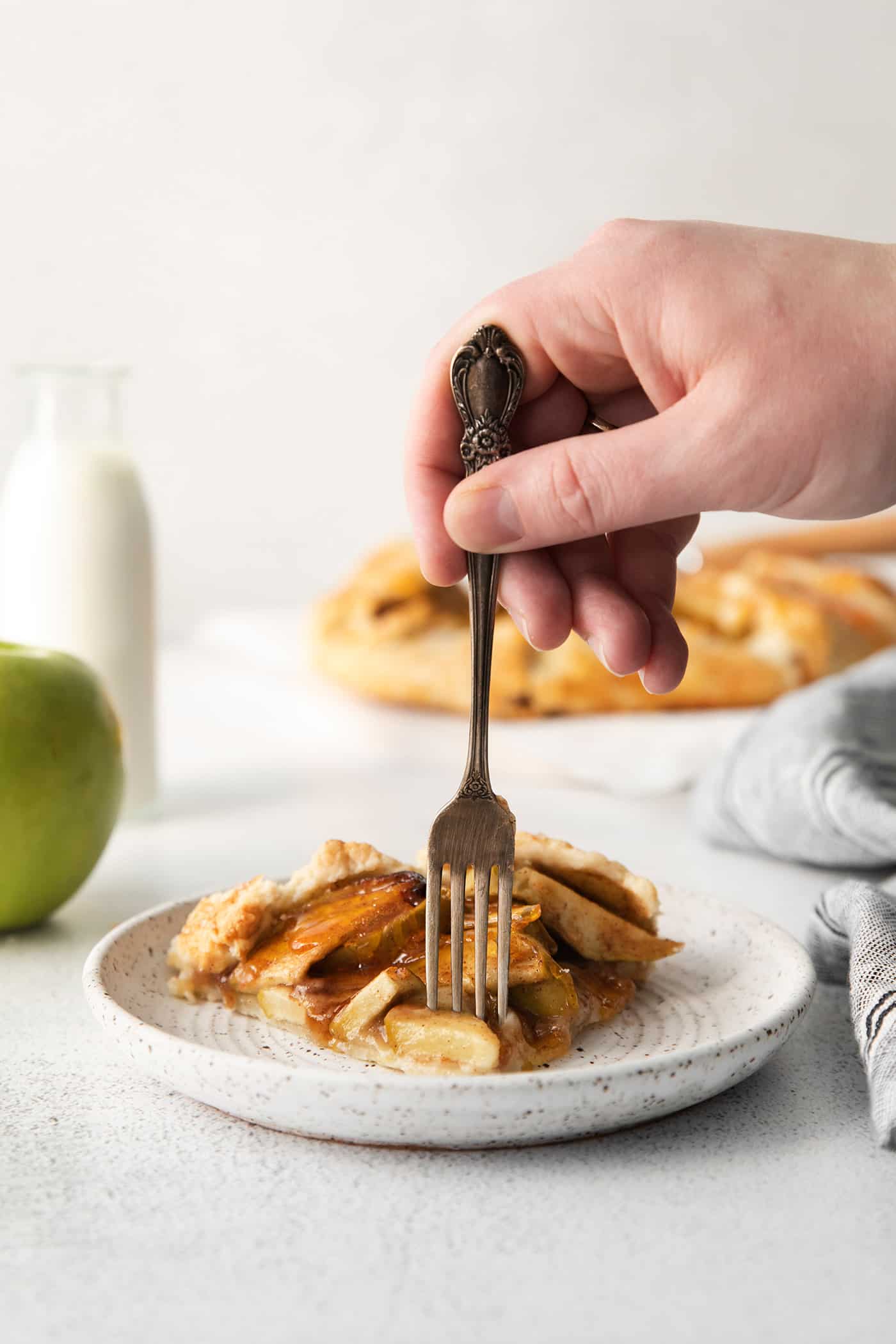 A fork taking a bite of an apple almond galette