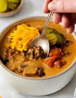 A spoon in a bowl of cheeseburger soup