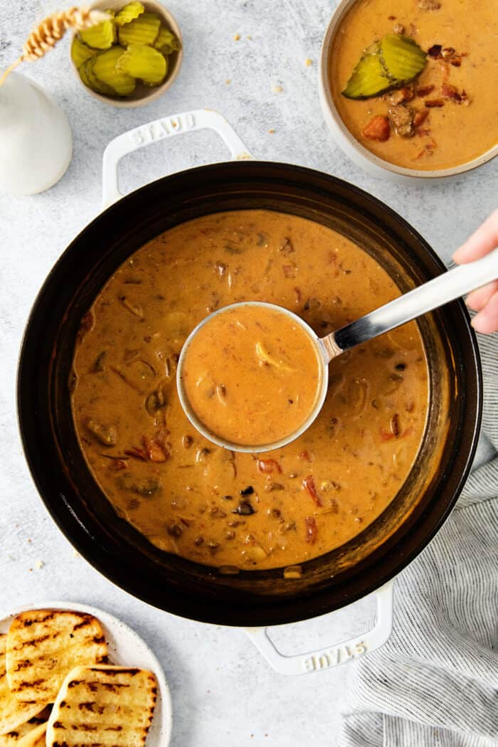 A ladle of soup over a pot of bacon cheeseburger soup