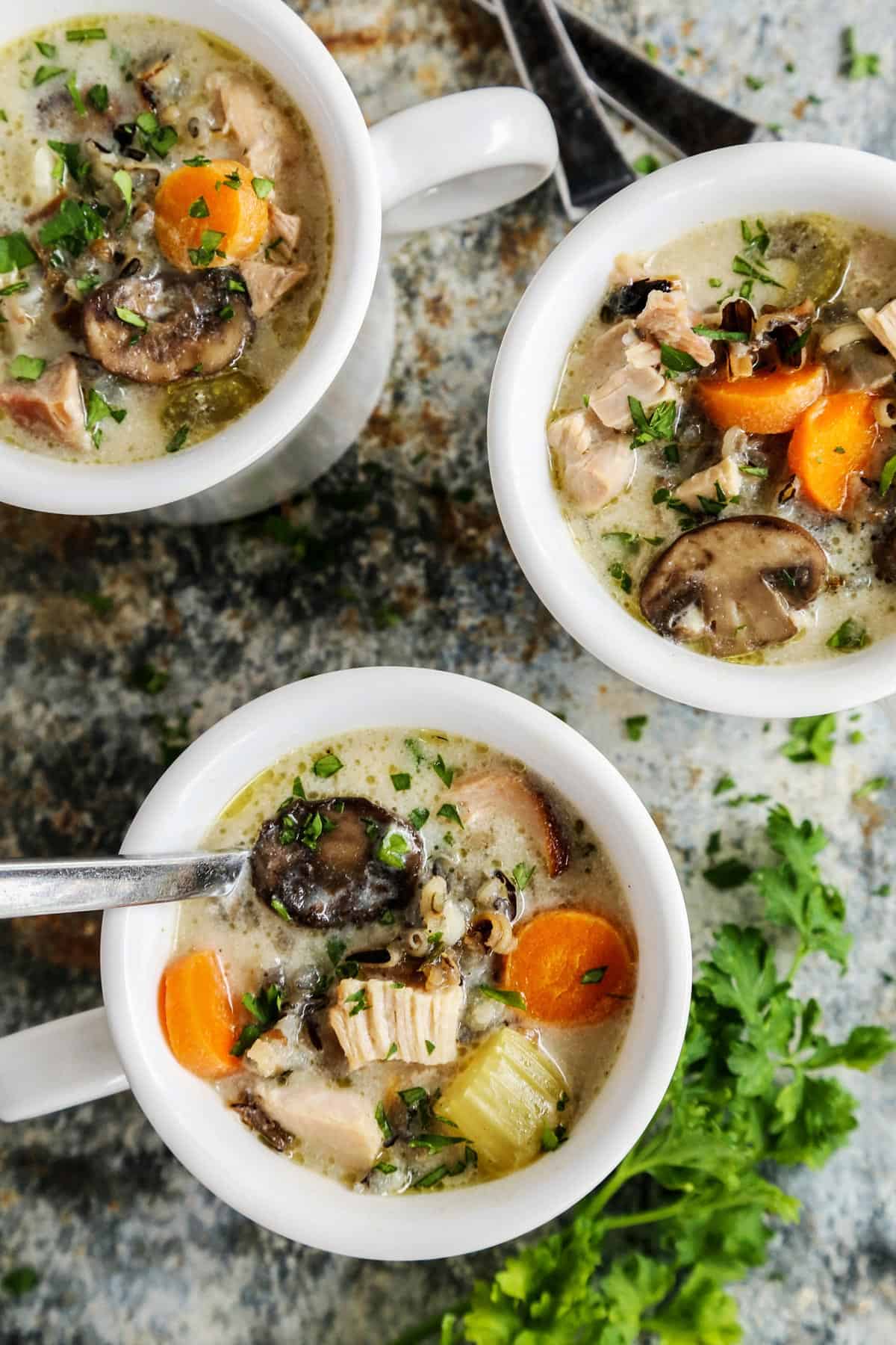 Overhead view of three mugs of chicken wild rice soup.