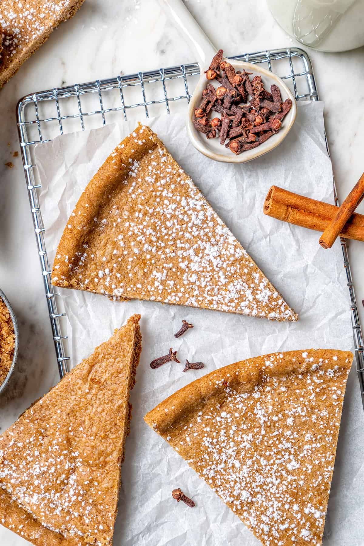 Spice cookies dusted with powdered sugar on wire rack