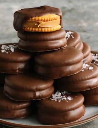 chocolate-dipped peanut butter Ritz cookies stacked on a plate