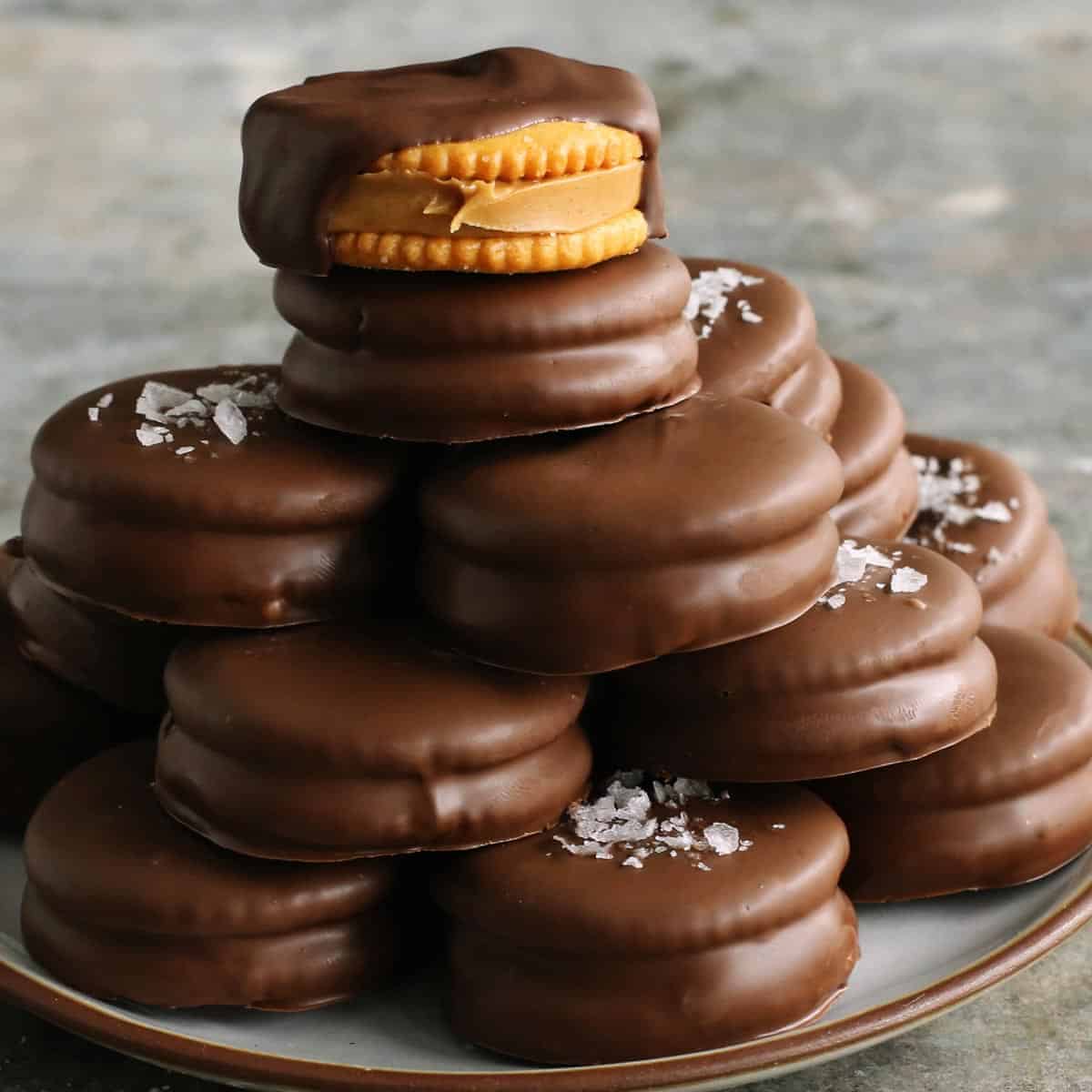 chocolate-dipped peanut butter Ritz cookies stacked on a plate