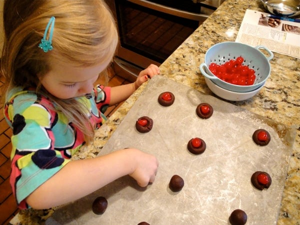 a young girl assembling cherry cookies