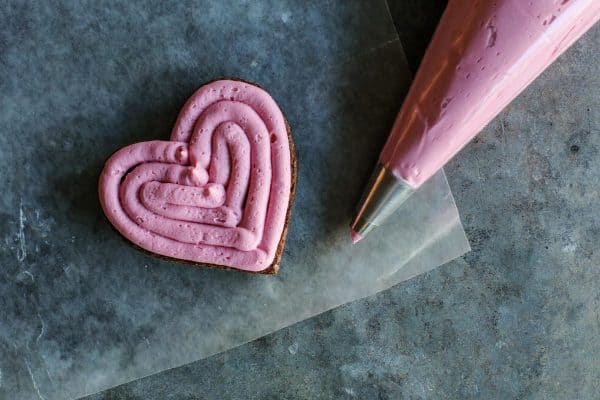 fresh raspberry buttercream piped onto a brownie