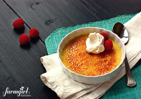 Almond Vanilla Bean Crème Brûlée Topped with Raspberries and Whipped Cream