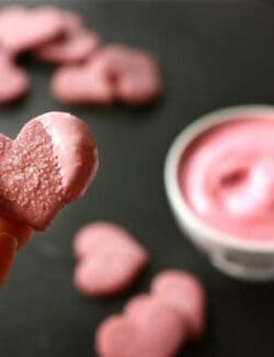 A heart shaped cookie dipped in pink frosting.