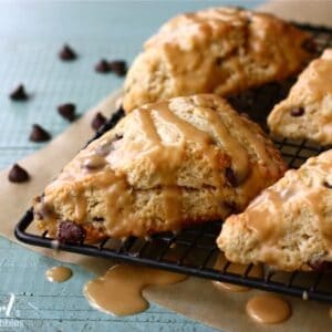Chocolate chip scones with peanut butter drizzle on a cooling rack