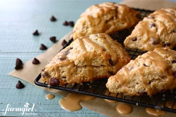 Chocolate chip scones with peanut butter drizzle on a cooling rack