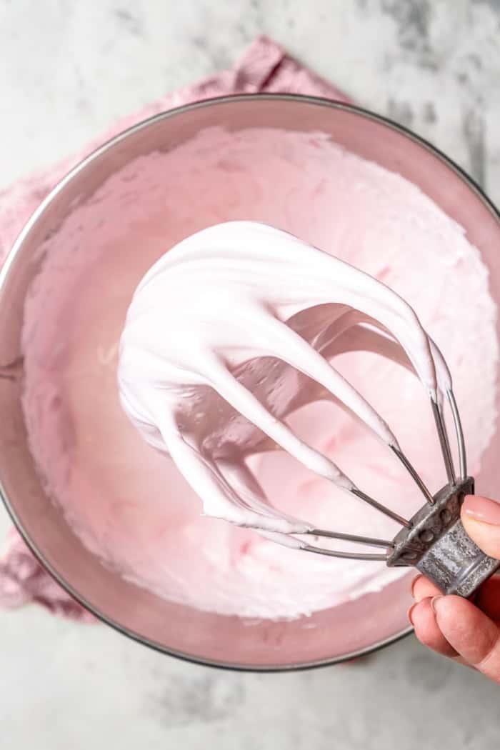 Marshmallow mixture on whisk attachment, showing thick and fluffy consistency