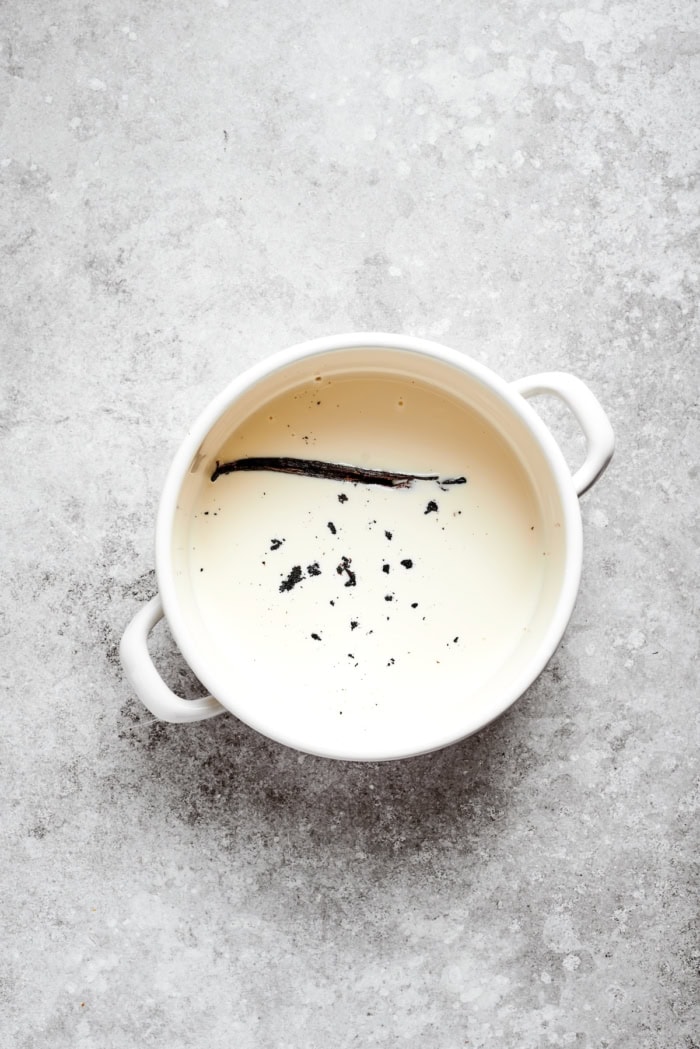 The silky custard in this Almond Vanilla Crème Brûlée lies beneath a glorious caramelized top. An elegant dessert that's surprisingly easy! Vanilla bean seeds and pot in pot of heavy cream.