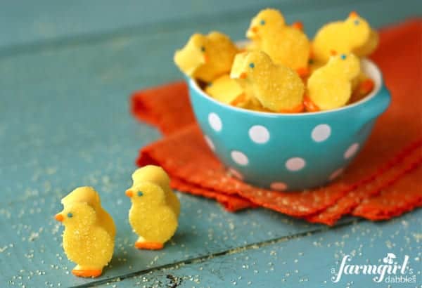 Yellow marshmallow chicks sprinkled with sugar in a blue bowl