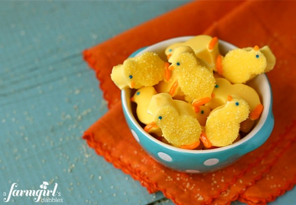 White chocolate covered marshmallow chicks piled in a blue bowl 