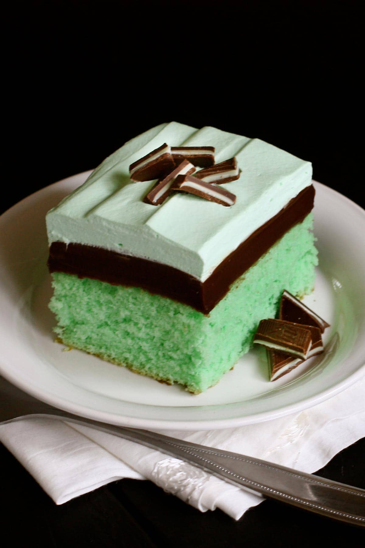 mint cake topped with a layer of hot fudge and mint flavored whipped cream