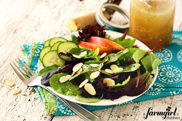 a salad with almonds, cucumbers, and dressing