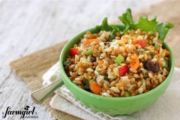 This healthy salad is full of texture and flavor with 3 wholesome grains and a variety of fruits and veggies. Perfect for meal prep lunches! a bowl of three grain and vegetable salad