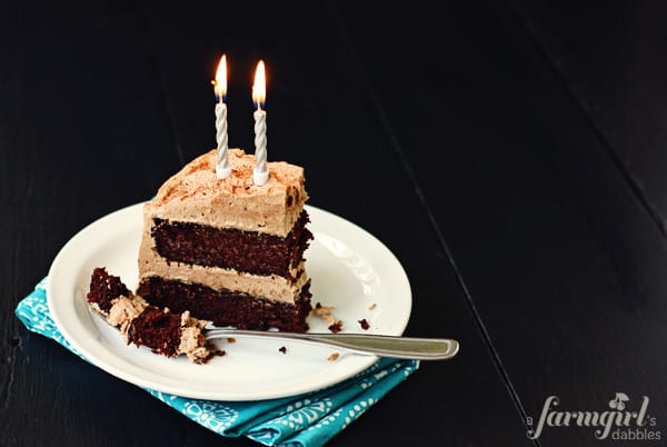 a slice of cake with two silver candles