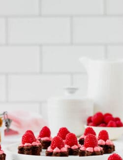 Brownie bites on a plate in front of a glass of milk