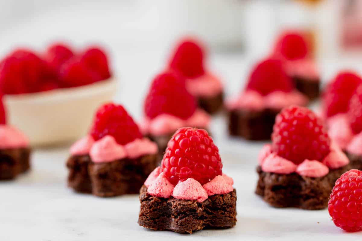 Mini brownies shaped like flowers, topped with raspberries