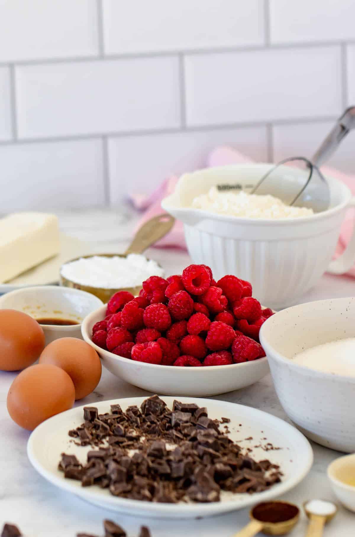 Small plates with chunks of chocolate, raspberries, and other ingredients