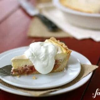 a slice of rhubarb cheesecake pie topped with whipped cream