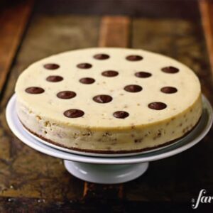 A toffee cheesecake on a white cake stand.