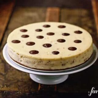a toffee cheesecake on a white cake stand