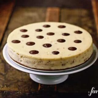 A toffee cheesecake on a white cake stand.