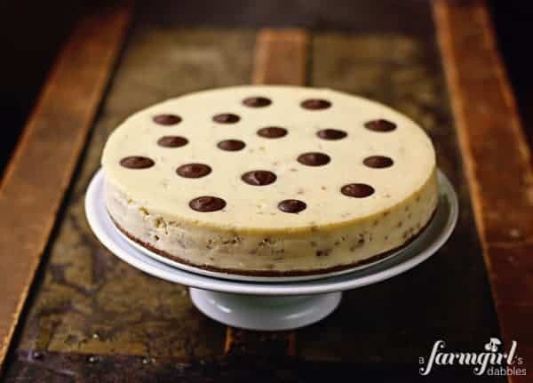 a toffee cheesecake on a white cake stand