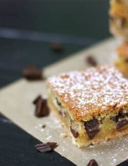 These chess pie bars are flaky, filled with chocolate chunks, topped with powdered sugar, and so delicious.