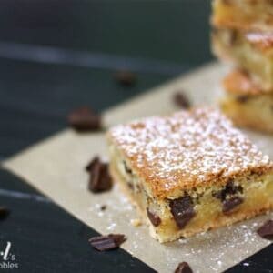 These chess pie bars are flaky, filled with chocolate chunks, topped with powdered sugar, and so delicious.