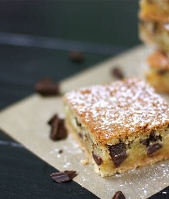 These chess pie bars are flaky, filled with chocolate chunks, topped with powdered sugar, and so delicious.