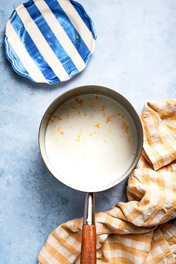 Overhead view of milk in pan with lemon zest