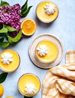 Overhead view of 4 lemon custard cups topped with whipped cream
