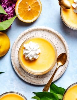 Overhead view of lemon custard cup on plate with whipped cream