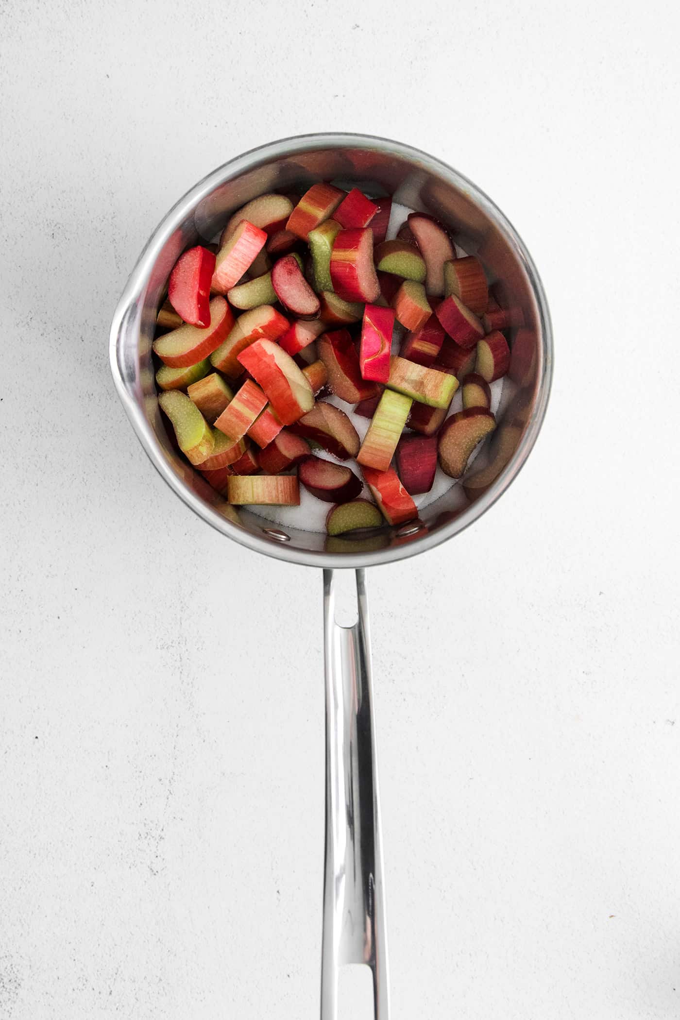 Pieces of rhubarb and water in a saucepan