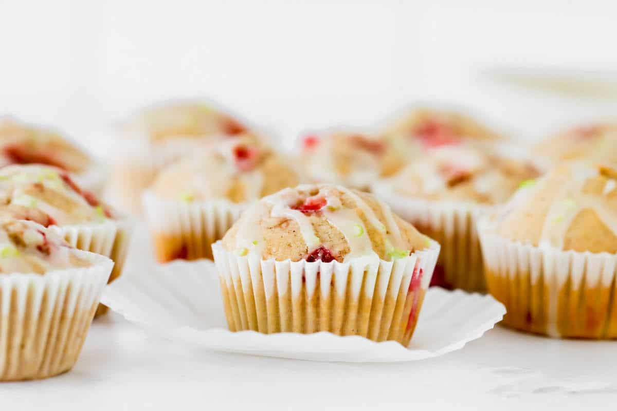 Several strawberry muffins, one with the wrapper pulled down